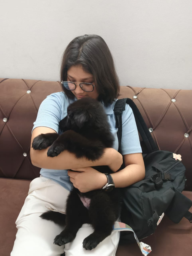 Customer cuddling black puppy